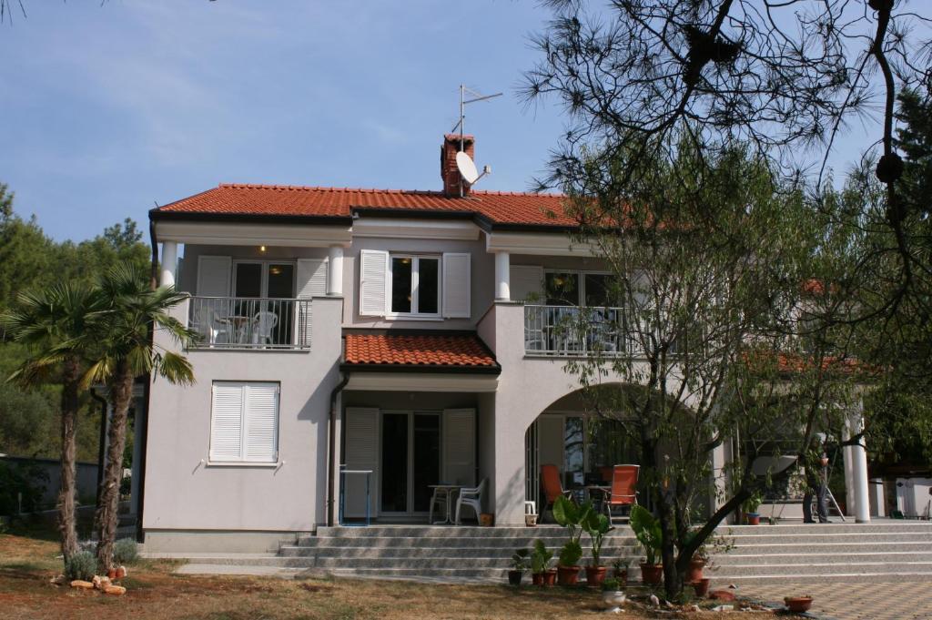 a white house with a cat on the roof at Apartments with a parking space Novigrad - 7017 in Novigrad Istria