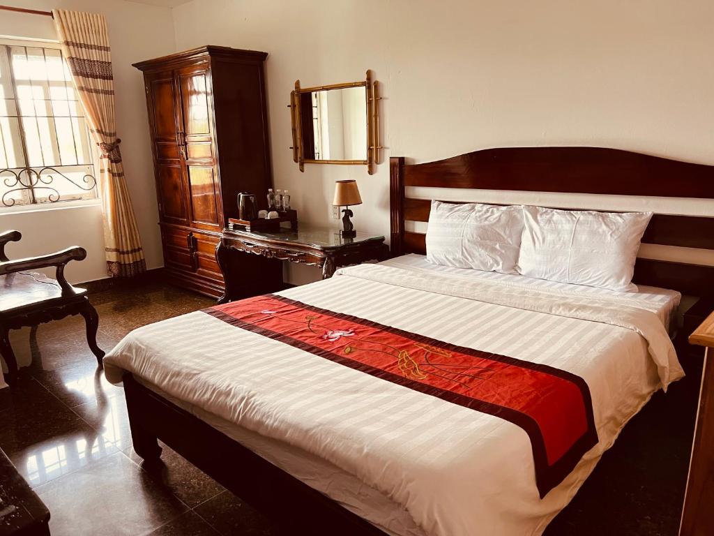 a bedroom with a large bed with a wooden headboard at Maison Vu Tri Vien in Hue