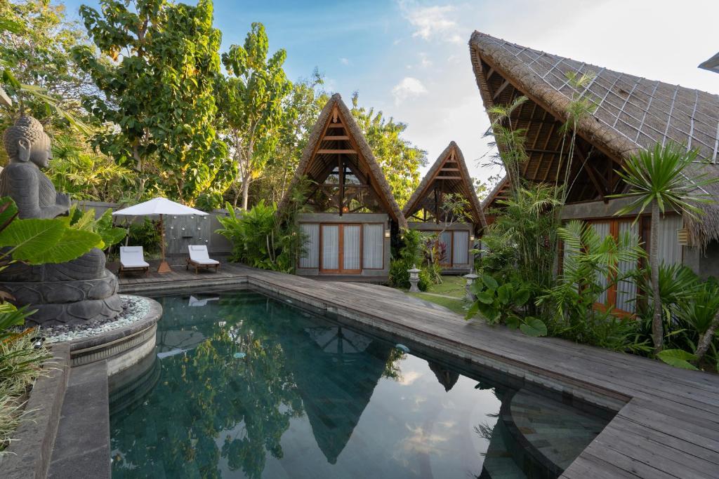 a villa with a swimming pool and a house at Villa Amantes Bingin in Uluwatu