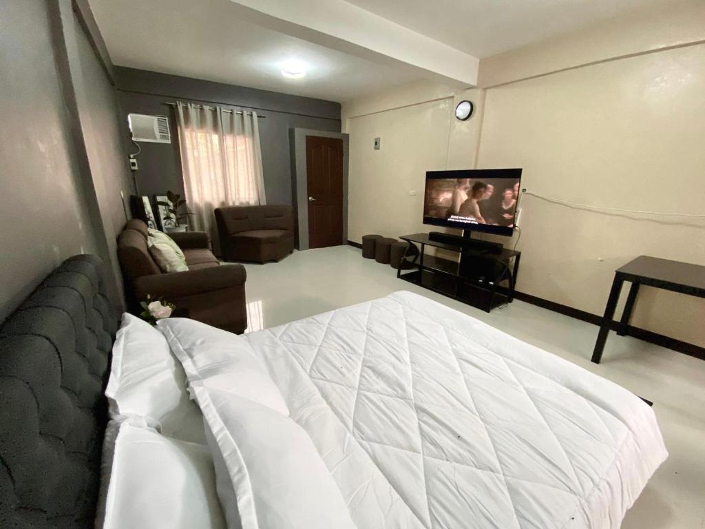 Sala de estar con cama grande y TV en Adam's Hotel Apartment en Pandi