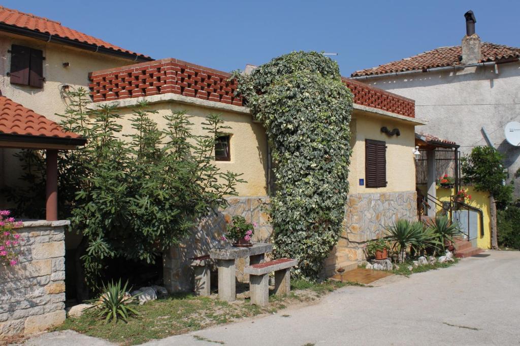 Una casa con una gran hiedra a un lado. en Holiday house with a swimming pool Rakotule, Central Istria - Sredisnja Istra - 7071, en Rakotule
