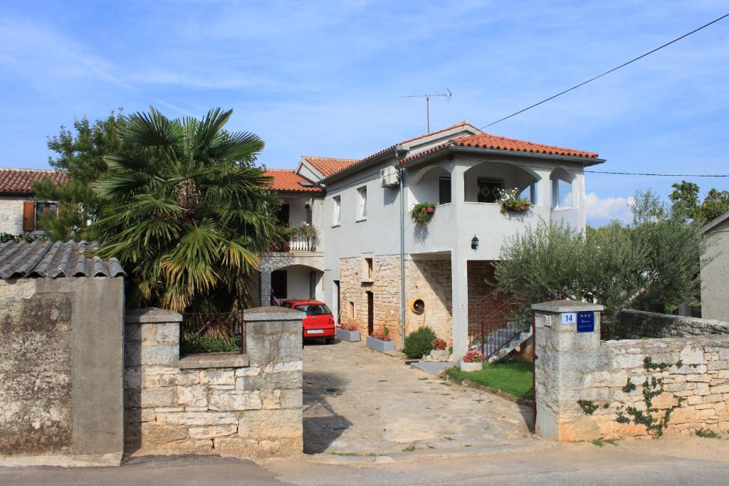 a white house with a palm tree and a driveway at Apartments with a parking space Tar, Porec - 7026 in Tar