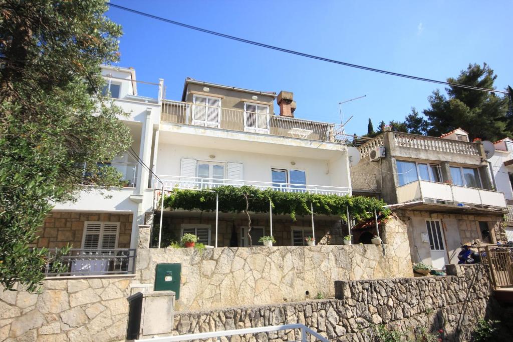 a white house on top of a stone wall at Apartments with WiFi Cavtat, Dubrovnik - 9063 in Cavtat