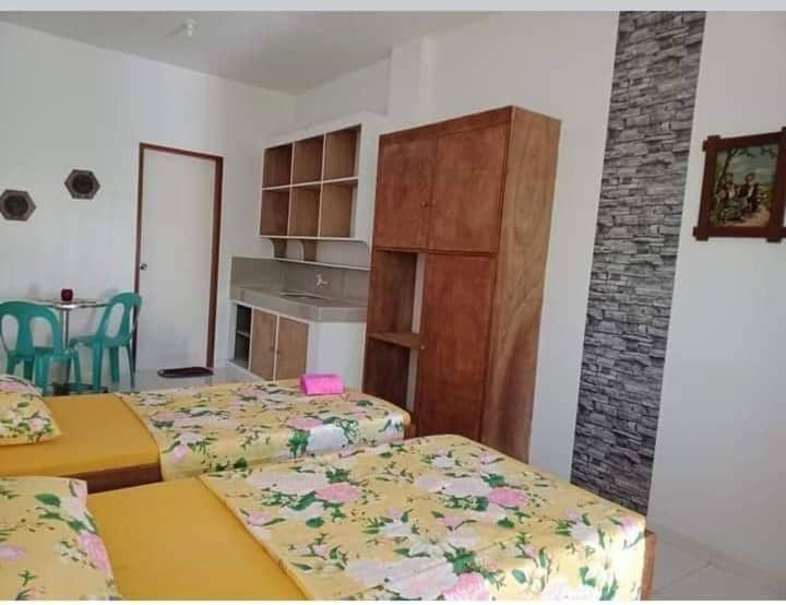 a bedroom with two beds and a kitchen with a table at Linden Apartment 