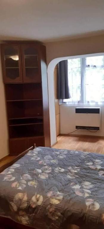ein Schlafzimmer mit einem Bett, einer Kommode und einem Fenster in der Unterkunft Квартира проспект Церетели in Tbilisi City