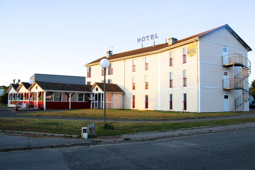 un grand bâtiment blanc sur le côté d'une rue dans l'établissement Larmor Plage Hotel, à Larmor-Plage