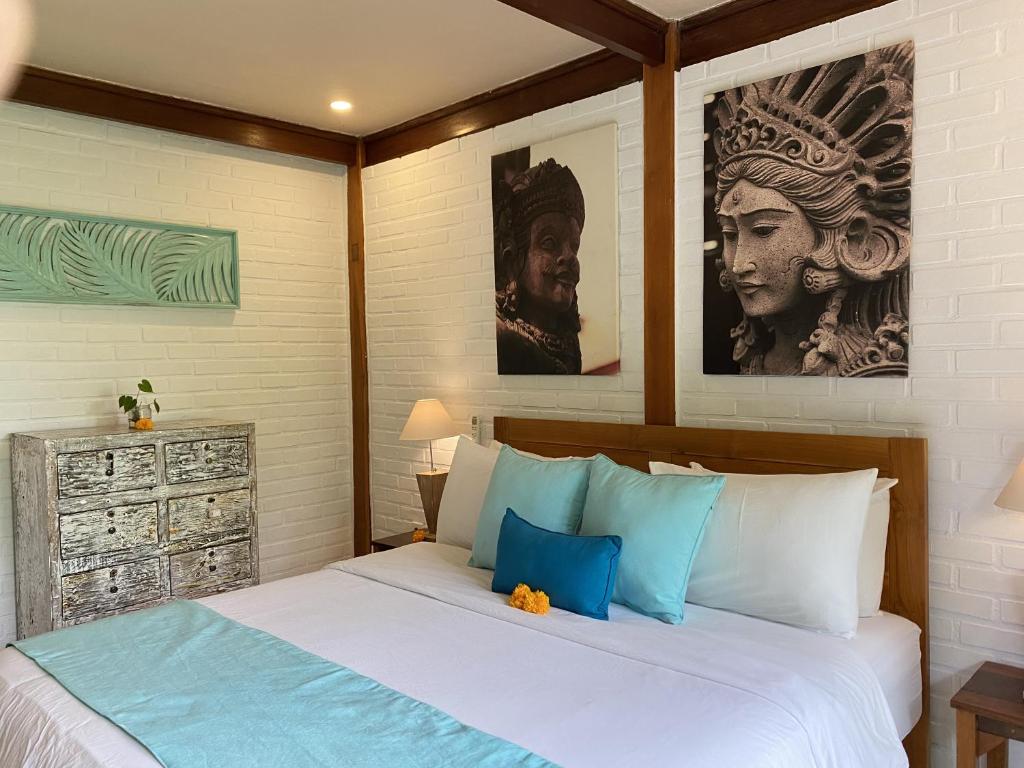 a bedroom with a bed with blue and white pillows at The Palms Canggu in Canggu