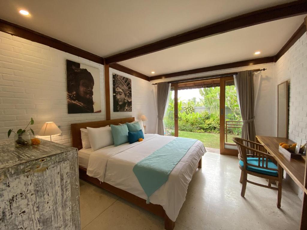a bedroom with a bed and a large window at The Palms Canggu in Canggu
