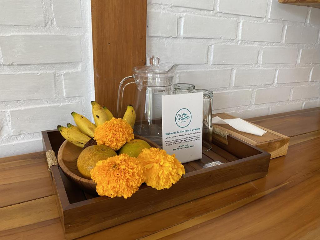 a vase of flowers and a candle on a shelf at The Palms Canggu in Canggu