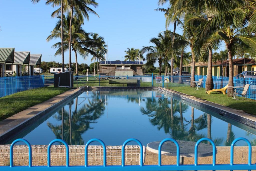 a pool at a resort with palm trees at Central Tourist Park in Mackay