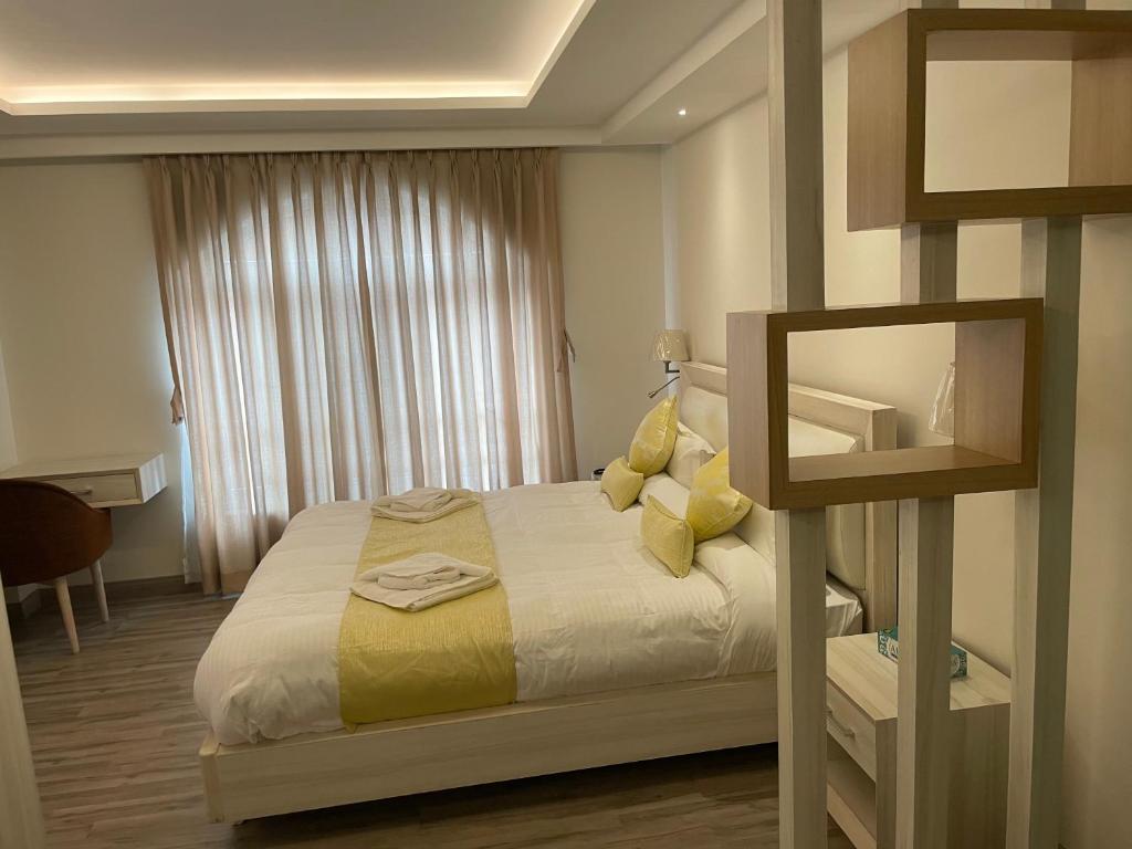 Un dormitorio con una cama con almohadas amarillas y una ventana en Palmo Holiday Apartments en Katmandú