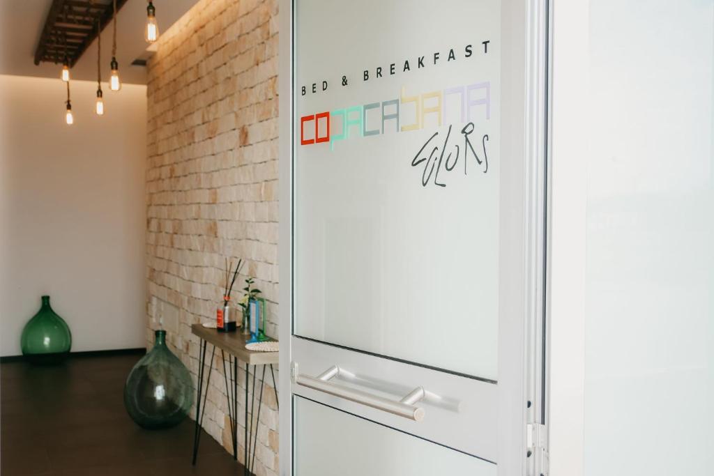 Cette chambre dispose d'un réfrigérateur blanc et d'un mur en briques. dans l'établissement B&B Copacabana Colors, à Margherita di Savoia