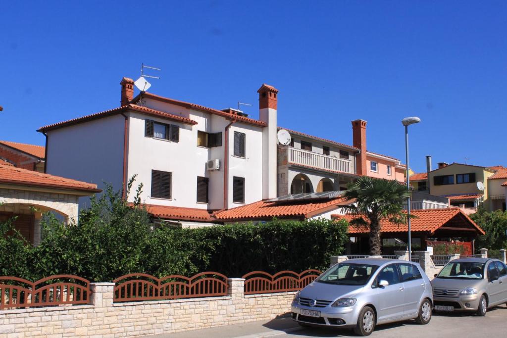 two cars parked in a parking lot in front of a building at Apartments by the sea Fazana - 7192 in Fažana