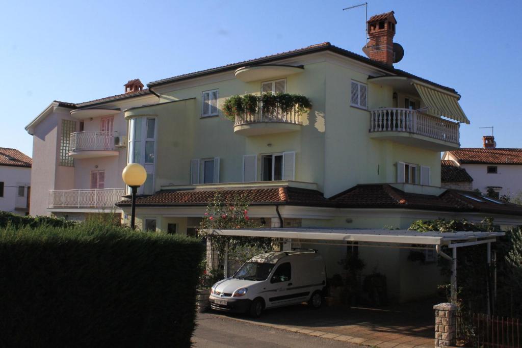 biały samochód zaparkowany przed budynkiem w obiekcie Apartments with a parking space Umag - 7147 w mieście Umag