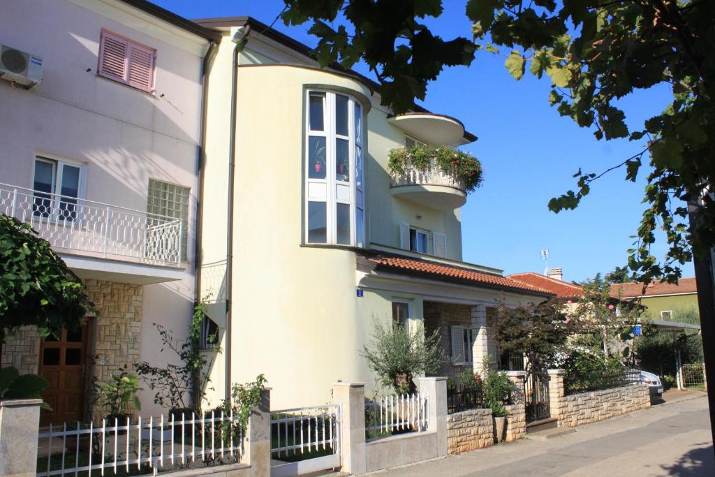 biały dom z balkonem na ulicy w obiekcie Apartments with a parking space Umag - 7147 w mieście Umag