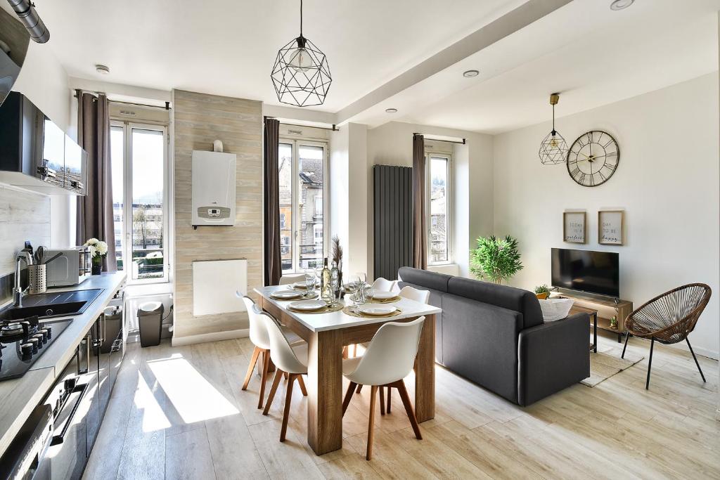 eine Küche und ein Wohnzimmer mit einem Tisch und Stühlen in der Unterkunft Appartement Cosy Bourgoin - Gare & Centre in Bourgoin