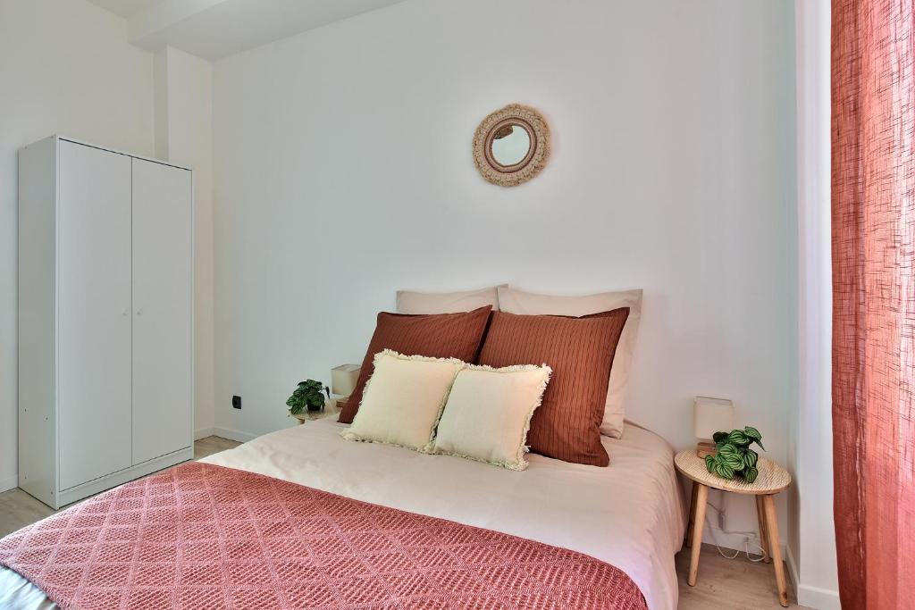 a bedroom with a bed with red and white pillows at Appartement Cosy Bourgoin - Gare &amp; Centre in Bourgoin