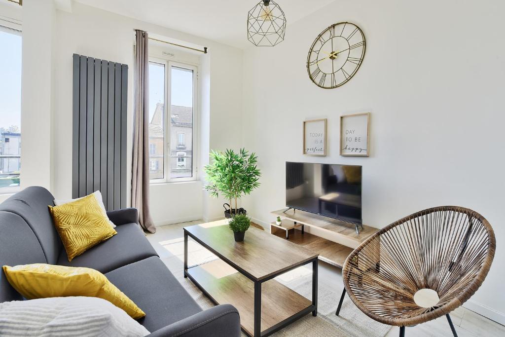 a living room with a couch and a table and a tv at Appartement Cosy Bourgoin - Gare &amp; Centre in Bourgoin