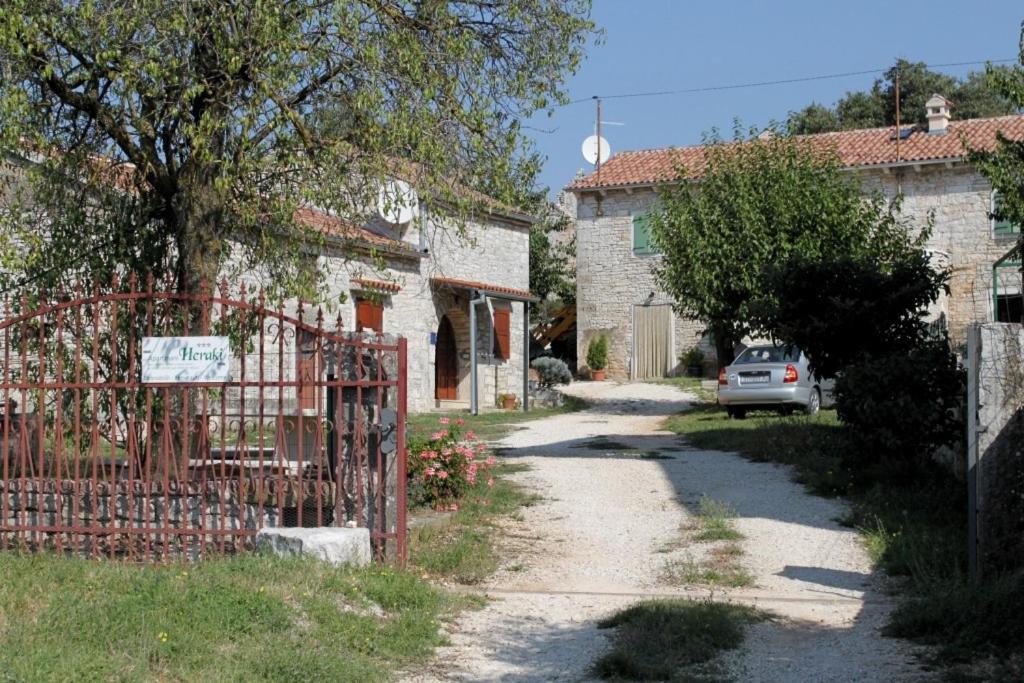 a gate to a house with a car on a driveway at Apartments with a parking space Heraki, Central Istria - Sredisnja Istra - 7167 in Stifanići