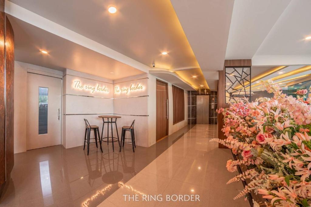 a lobby of a hotel with a bar and flowers at The Ring Border in Ban Khlong Phruan