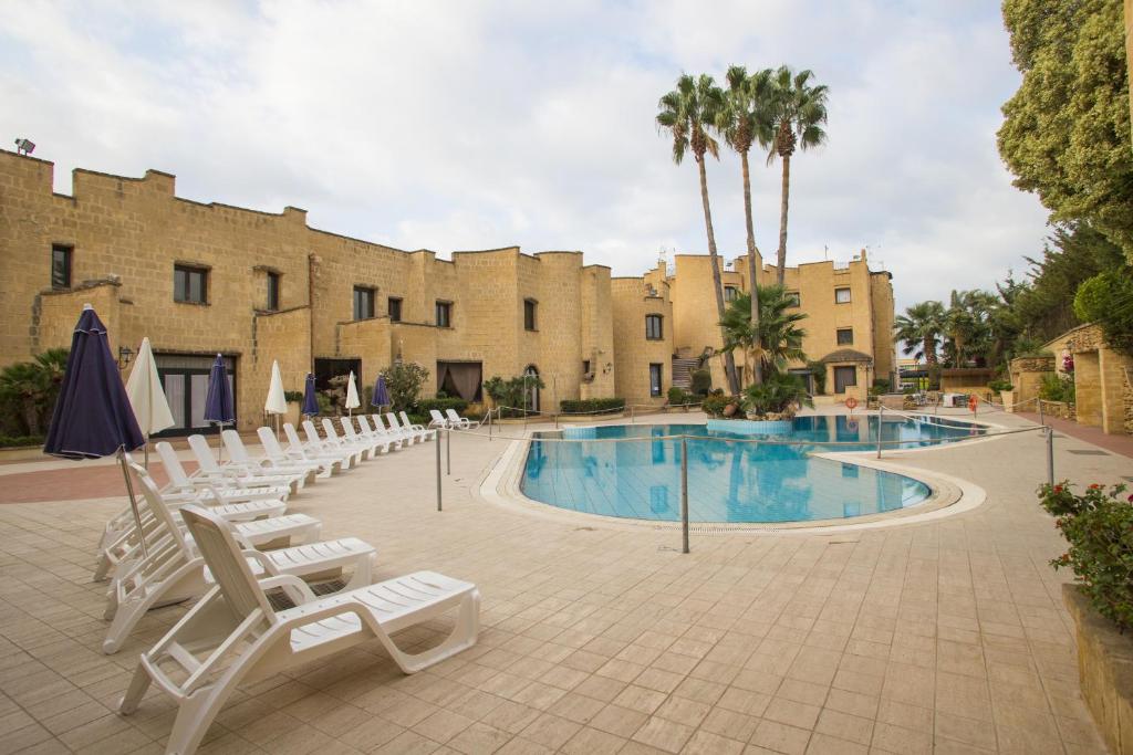 a resort with a pool and chairs and a building at Grand Hotel Mosè in Villaggio Mosè