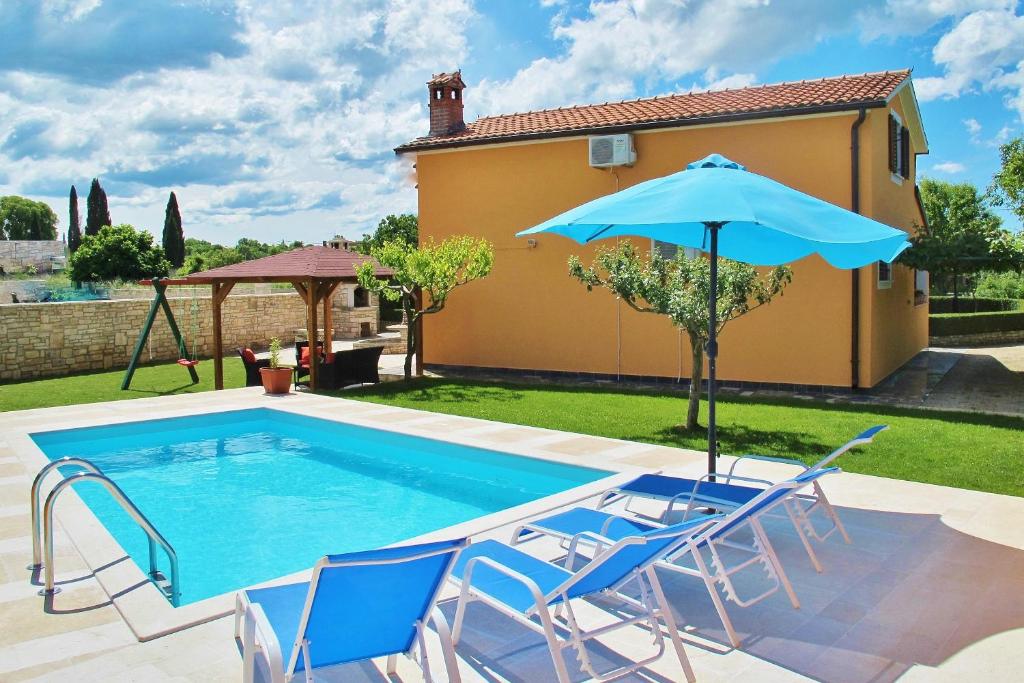 una piscina con sillas y sombrilla en Family friendly house with a swimming pool Sveti Petar u Sumi, Central Istria - Sredisnja Istra - 7177 en Gljuščići