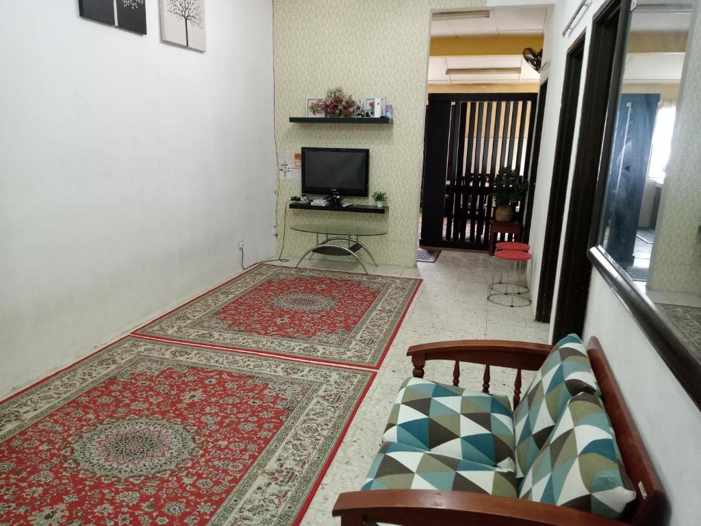 ein Wohnzimmer mit einem TV und einem Teppich in der Unterkunft FirZan Homestay Bukit Mahkota in Kajang