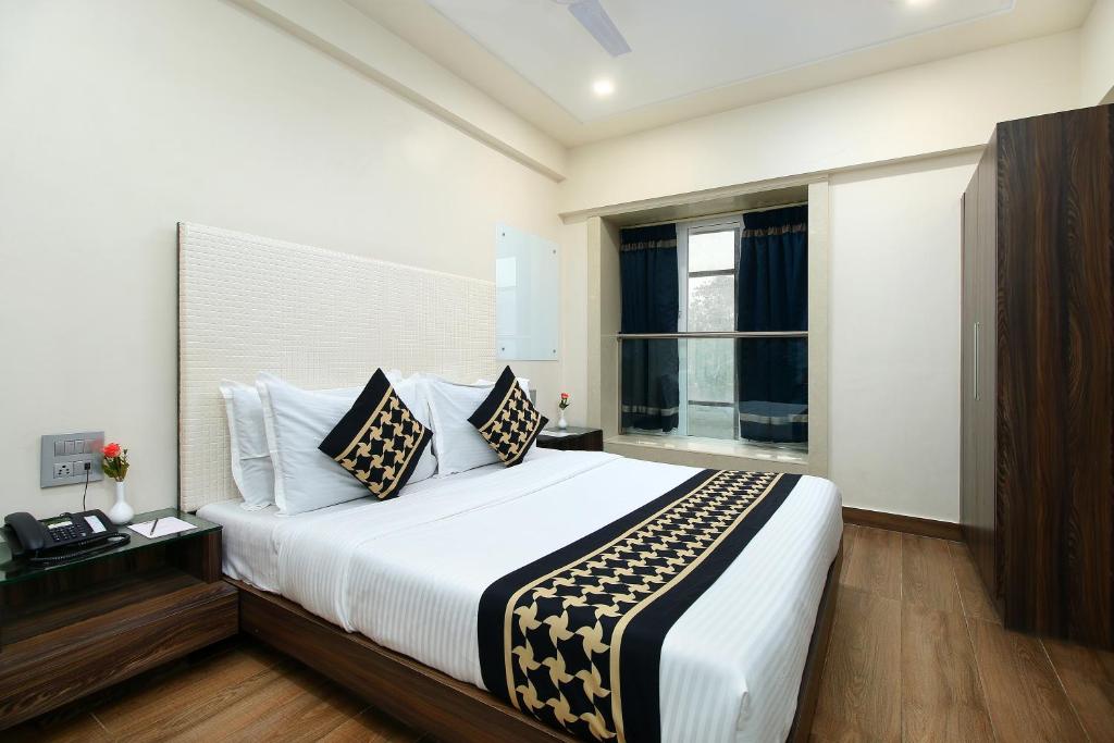 um quarto com uma cama grande e uma janela em Hotel Mumbai House Juhu, Santacruz West, Mumbai em Mumbai