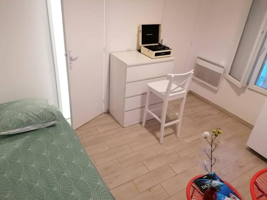 a small room with a table and a chair and a desk at Superbe logement(C) avec Parking Gratuit sur place in Drancy
