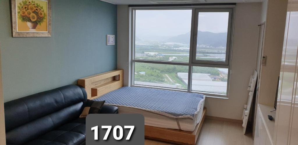 a room with a couch and a large window at Gimcheon Gumi KTX Yulgokdong Apartment in Gimcheon