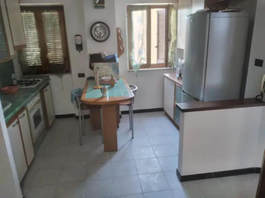 Il comprend une cuisine équipée d'une table et d'un réfrigérateur. dans l'établissement Sardinia Home Flat 4 beds in Carbonia, à Carbonia
