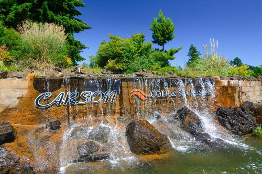 Carson Hot Springs Resort & Spa في Carson: شلال في حديقة مع رسومات على الجدران