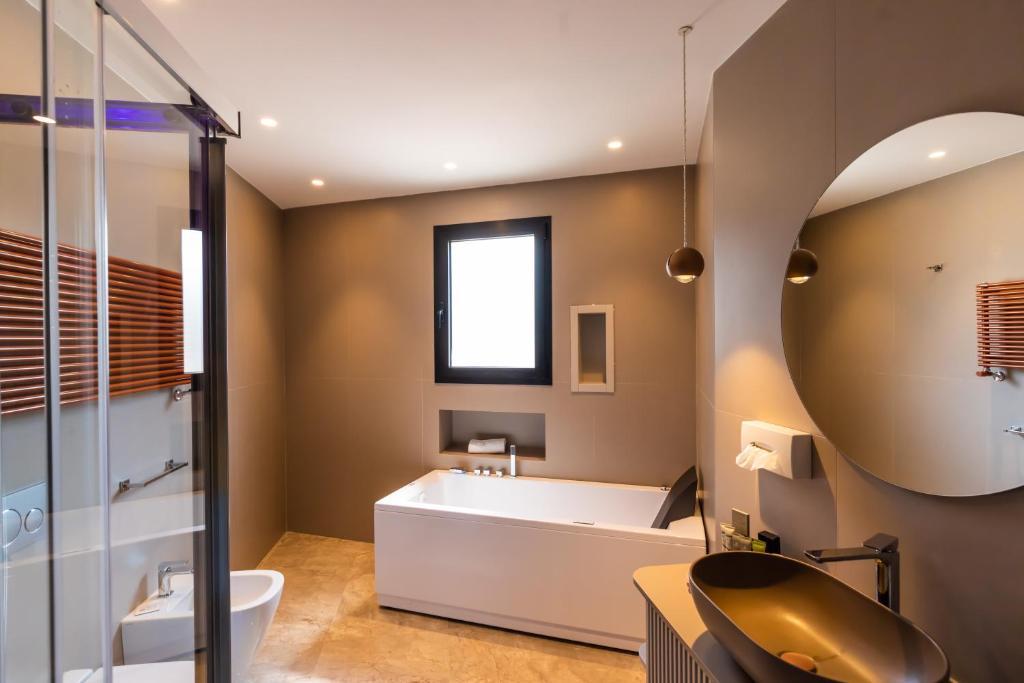 a bathroom with a tub and a sink at Solmaris Tropea Rooms & Suites in Tropea