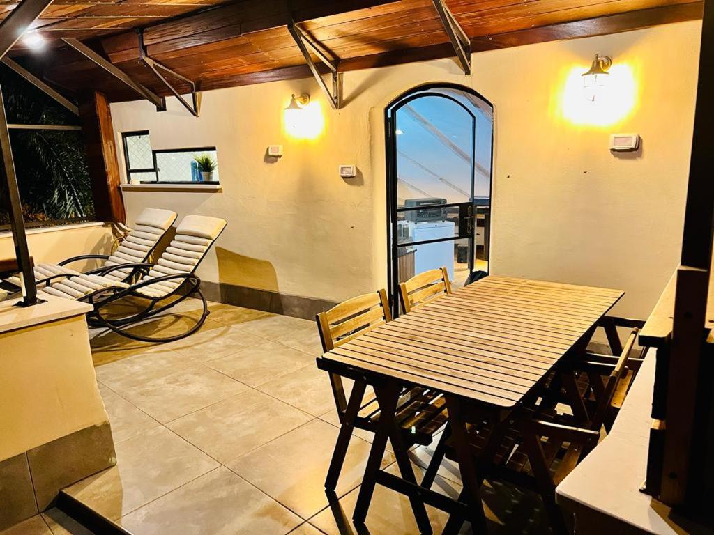 a patio with a wooden table and chairs on a balcony at תניא in Gilon