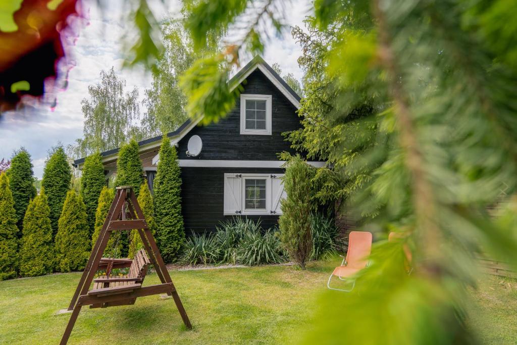 a black house with a ladder in front of it at Black&White in Kołczewo