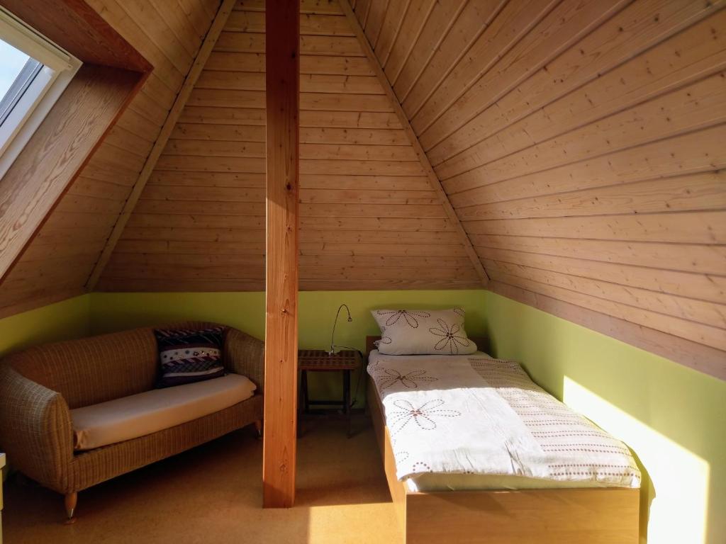 Habitación con cama y sofá en el ático en Aalens schönste Aussicht, en Aalen
