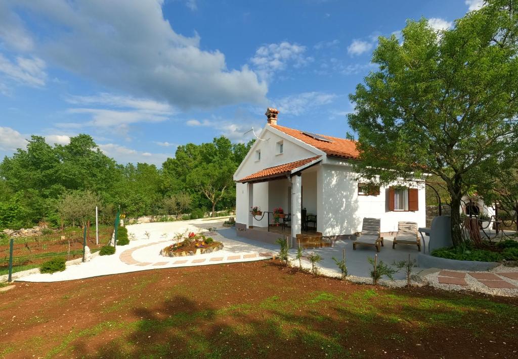 a small white house with a garden and a yard at Spignoviza in Kanfanar