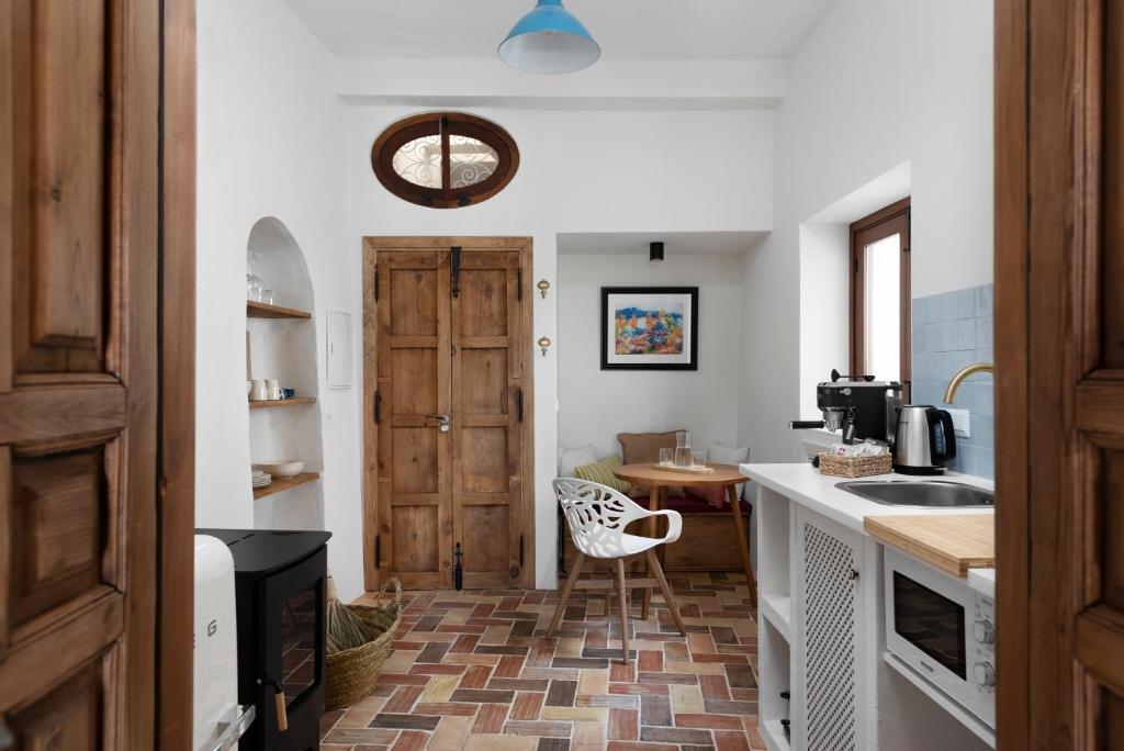 a kitchen with a wooden door and a table at La AMARA Zaid - en el casco antiguo de Frigiliana in Frigiliana