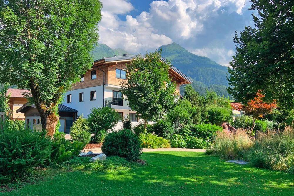 a house in the middle of a yard with trees at Apartment in Bramberg am Wildkogel with terrace in Bramberg am Wildkogel