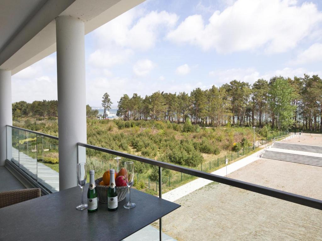 een balkon met een tafel met wijnglazen erop bij Dünenresidenz Prora - Ferienwohnung mit Meerblick, 2 Schlafzimmern und Loggia NP-318 in Binz