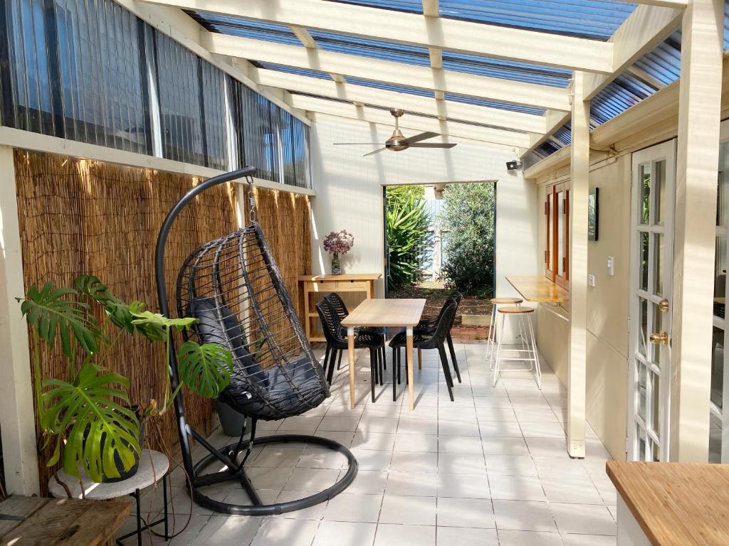 a conservatory with a table and chairs and a ceiling at Wayfarers Cottage in Goolwa