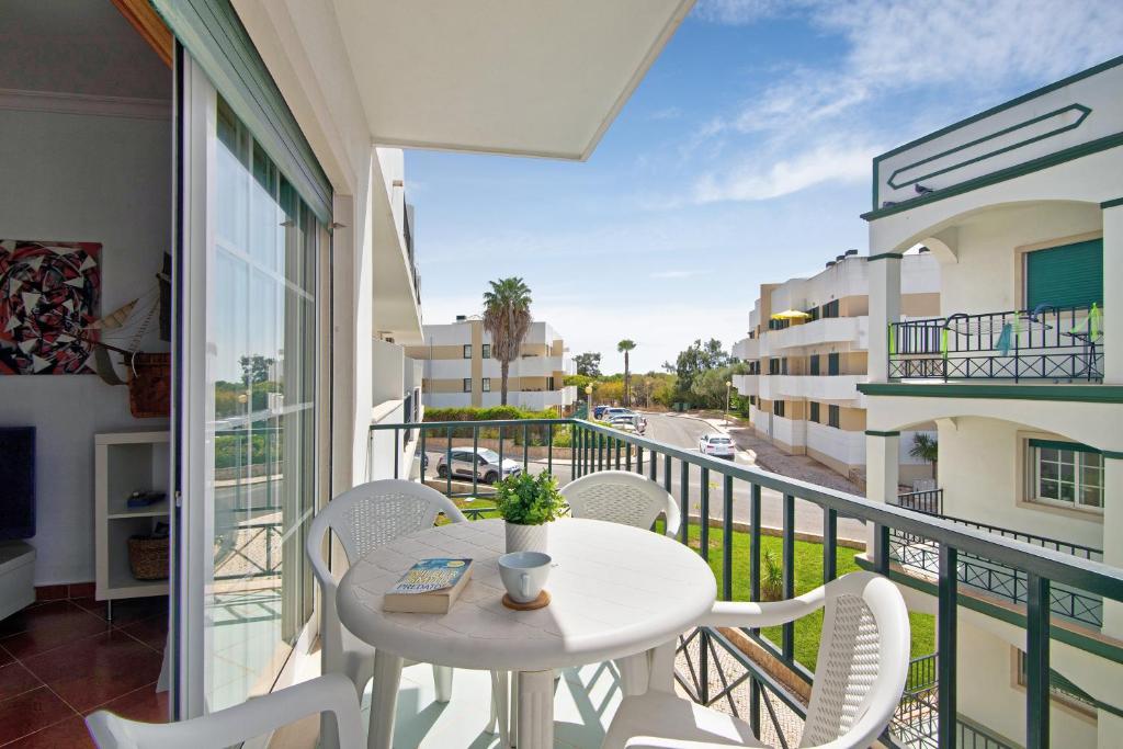 balcone con tavolo, sedie e vista sulla strada di Sol do Algarve a Conceição