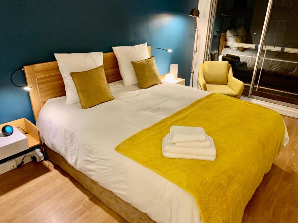 a bedroom with a large bed with a yellow blanket at Central Montparnasse / Voyage d'affaire / Découverte de la ville in Paris