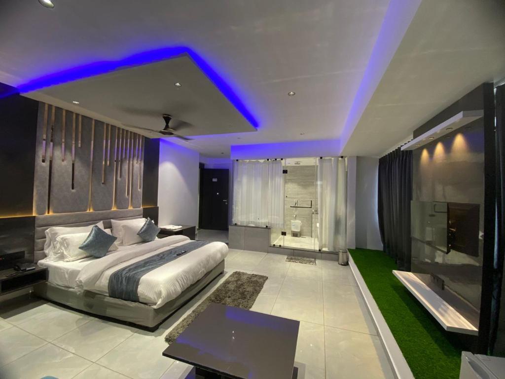 a bedroom with a bed and a purple lighting at HOTEL CROWN PALACE in Surat