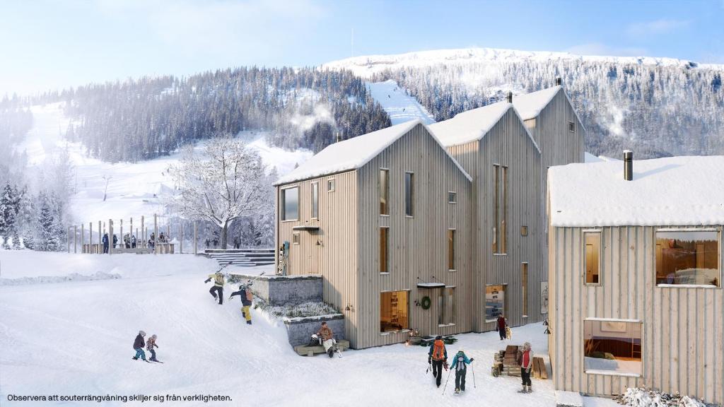 Un groupe de personnes debout dans la neige à côté d'un bâtiment dans l'établissement Viste Funäsdalen, à Funäsdalen