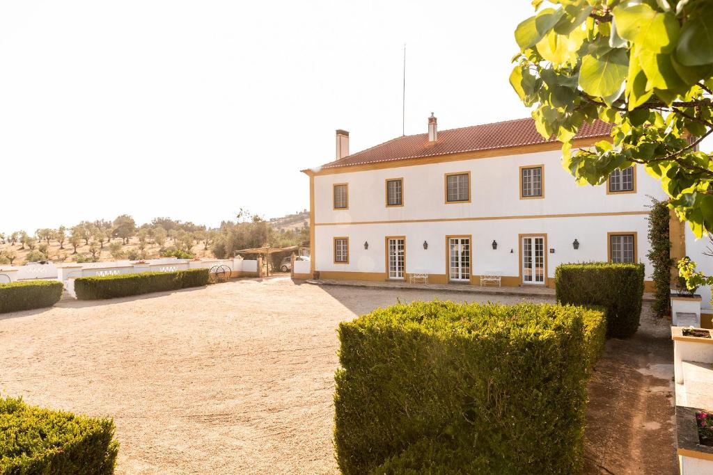 a large white house with hedges in front of it at Herdade da Ordem in Cabeço de Vide