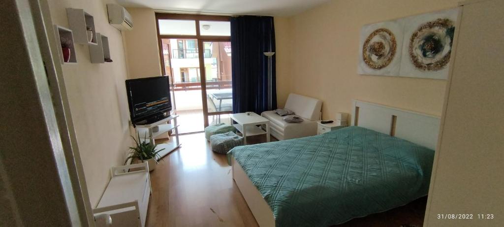 a bedroom with a green bed and a television at Apartment Milanovi in Sozopol