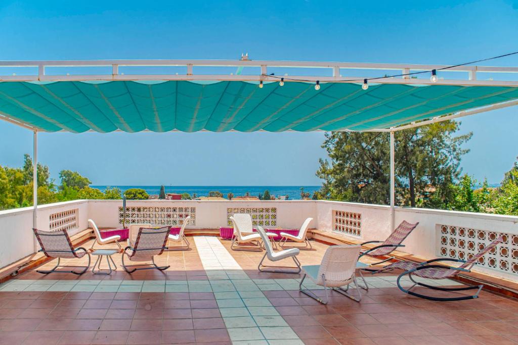 馬拉加的住宿－馬拉加莫拉加波尼旅舍，一组椅子,位于一个有海洋背景的庭院