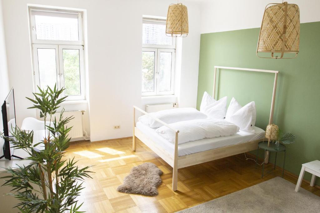 a bedroom with a white bed and green walls at Sunny Apartment near Belvédère Castle in Vienna