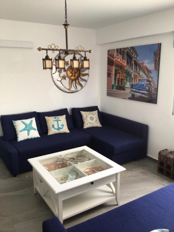 uma sala de estar com um sofá azul e uma mesa em Le Montemar em Alicante